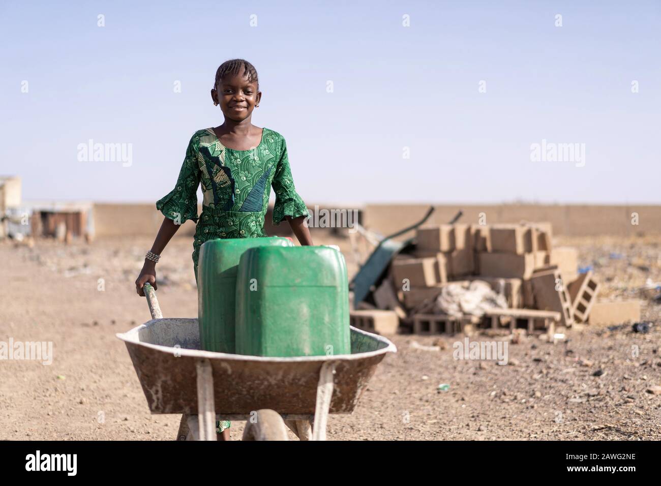 Cute African Girl Carrying Fresh Water in Bamako Stock Photo