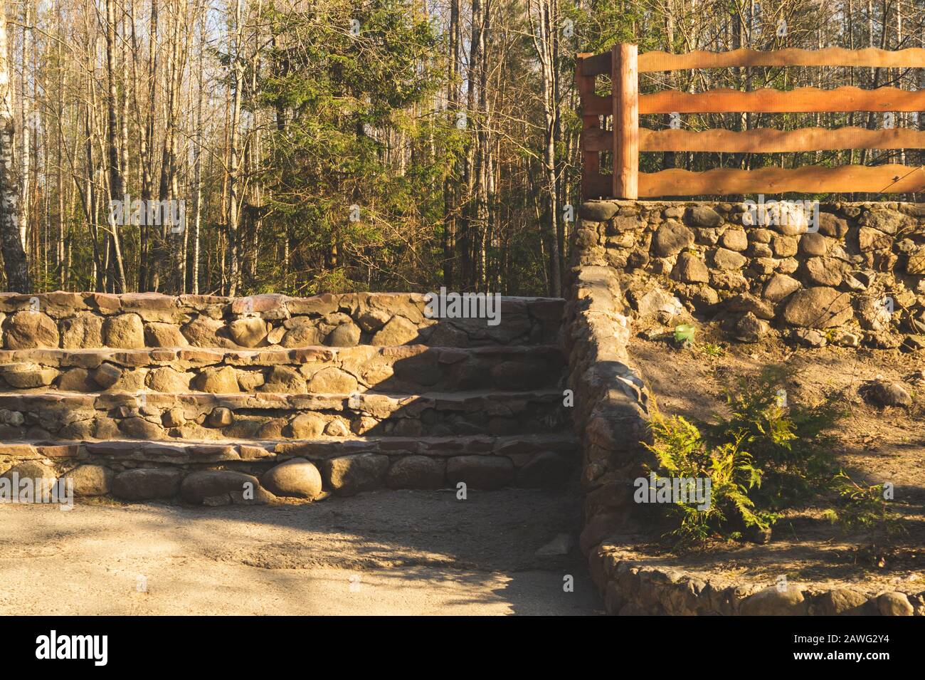 Natural stone ladder in the park. wooden fencing. nature background Stock Photo
