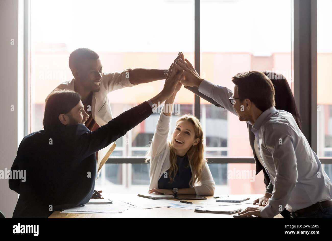 Happy diverse employees team giving high five in boardroom Stock Photo ...