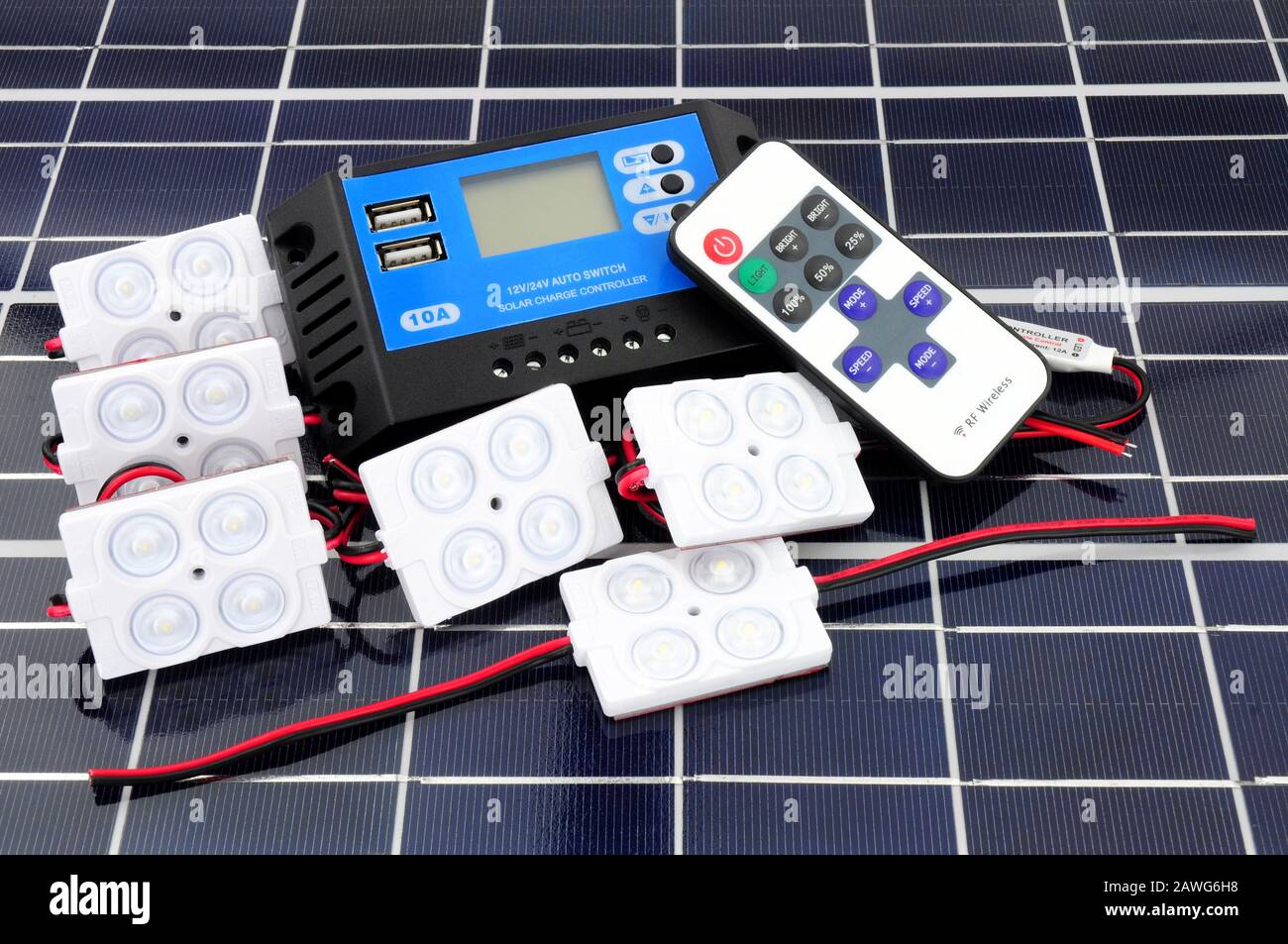 Solar lighting kit with lights and charger control unit and remote control on a solar panel background Stock Photo