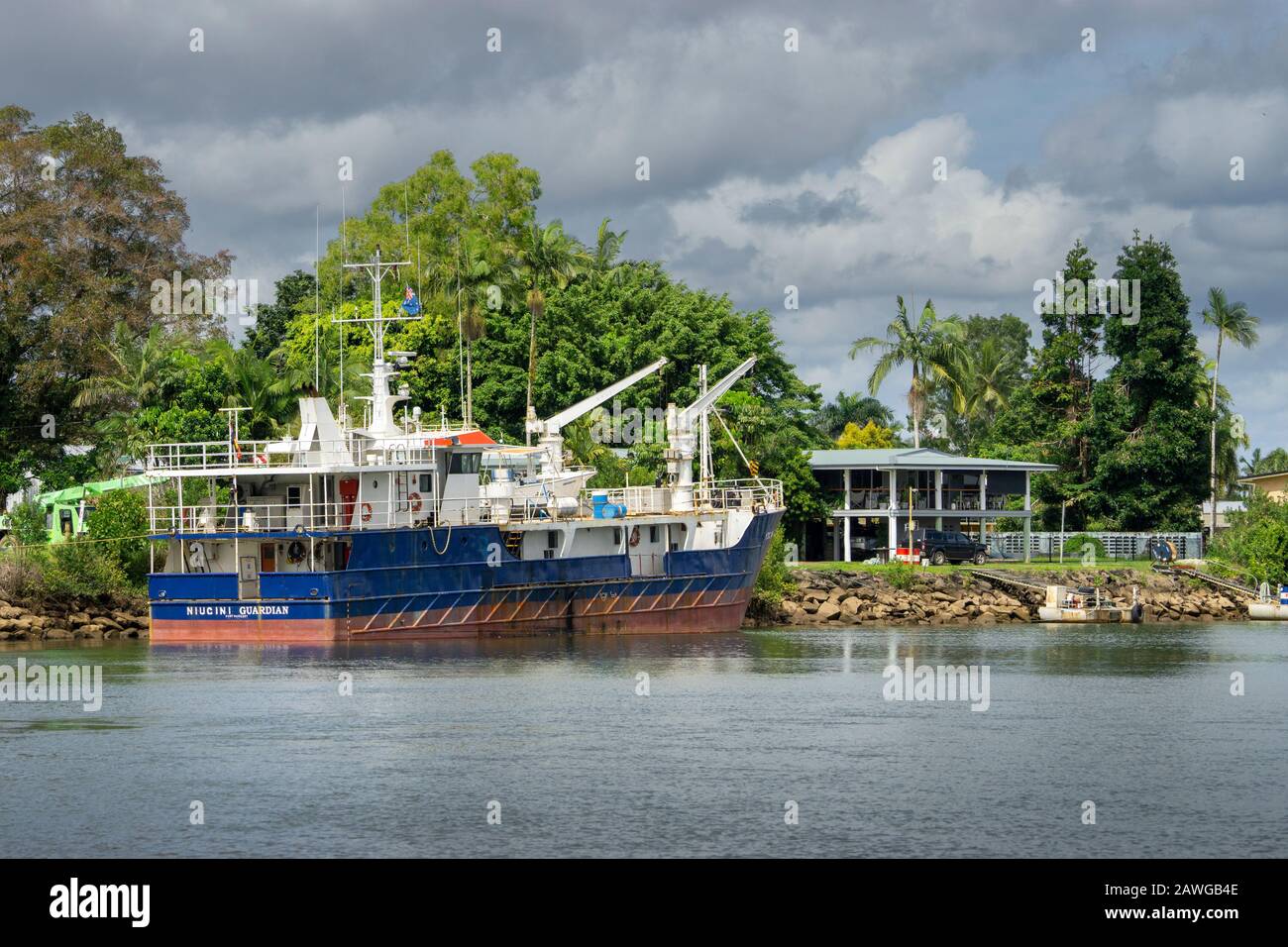Small commercial boat moored on banks of Johnstone River in Innisfail