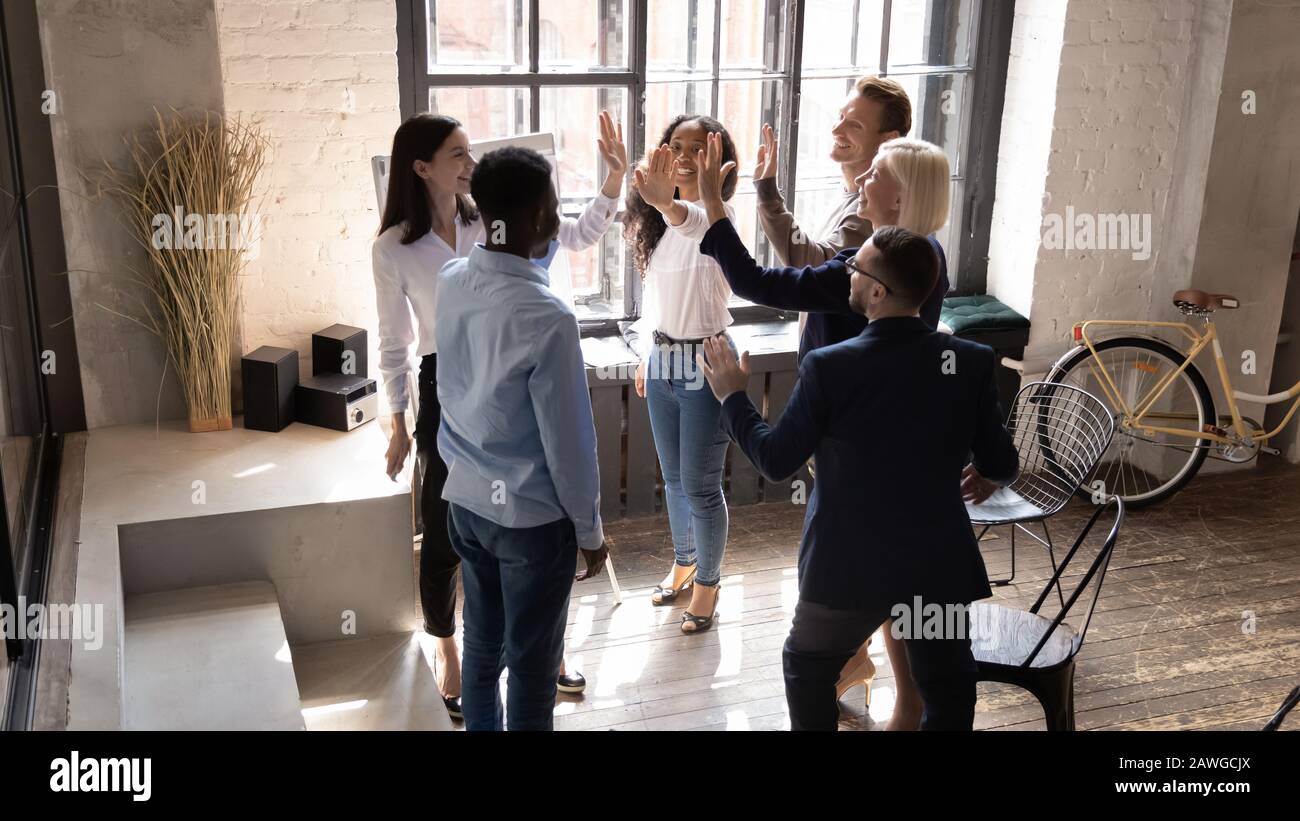 Diverse workers giving high five gesture of partnership and synergy ...