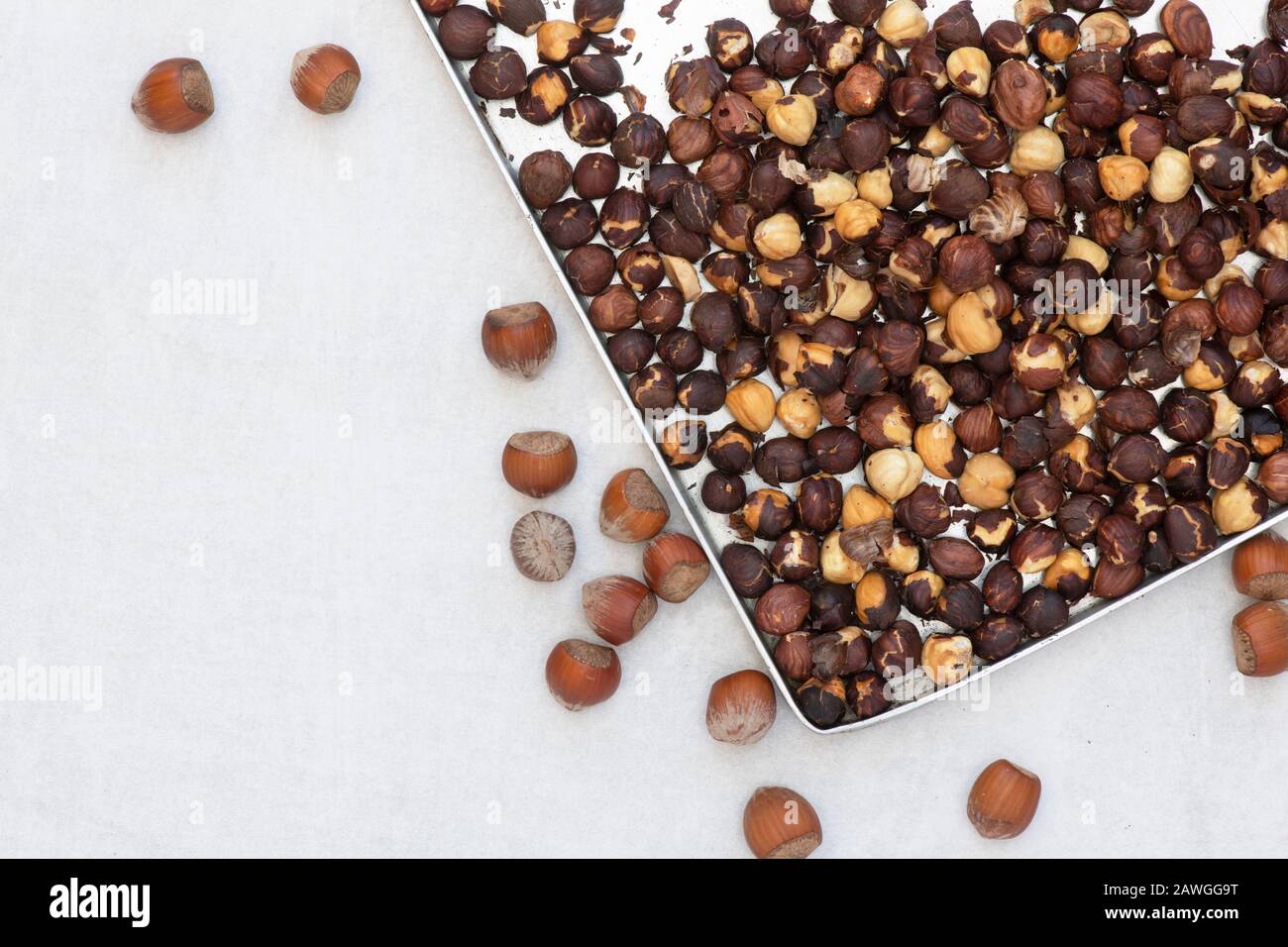 Corylus avellana. Roasted Hazelnuts on a baking tray for making homemade vegan hazelnut chocolate spread Stock Photo