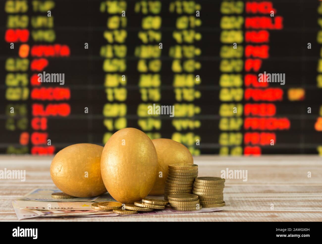 golden eggs,coins,banknote with the stock price board background. selective focus Stock Photo