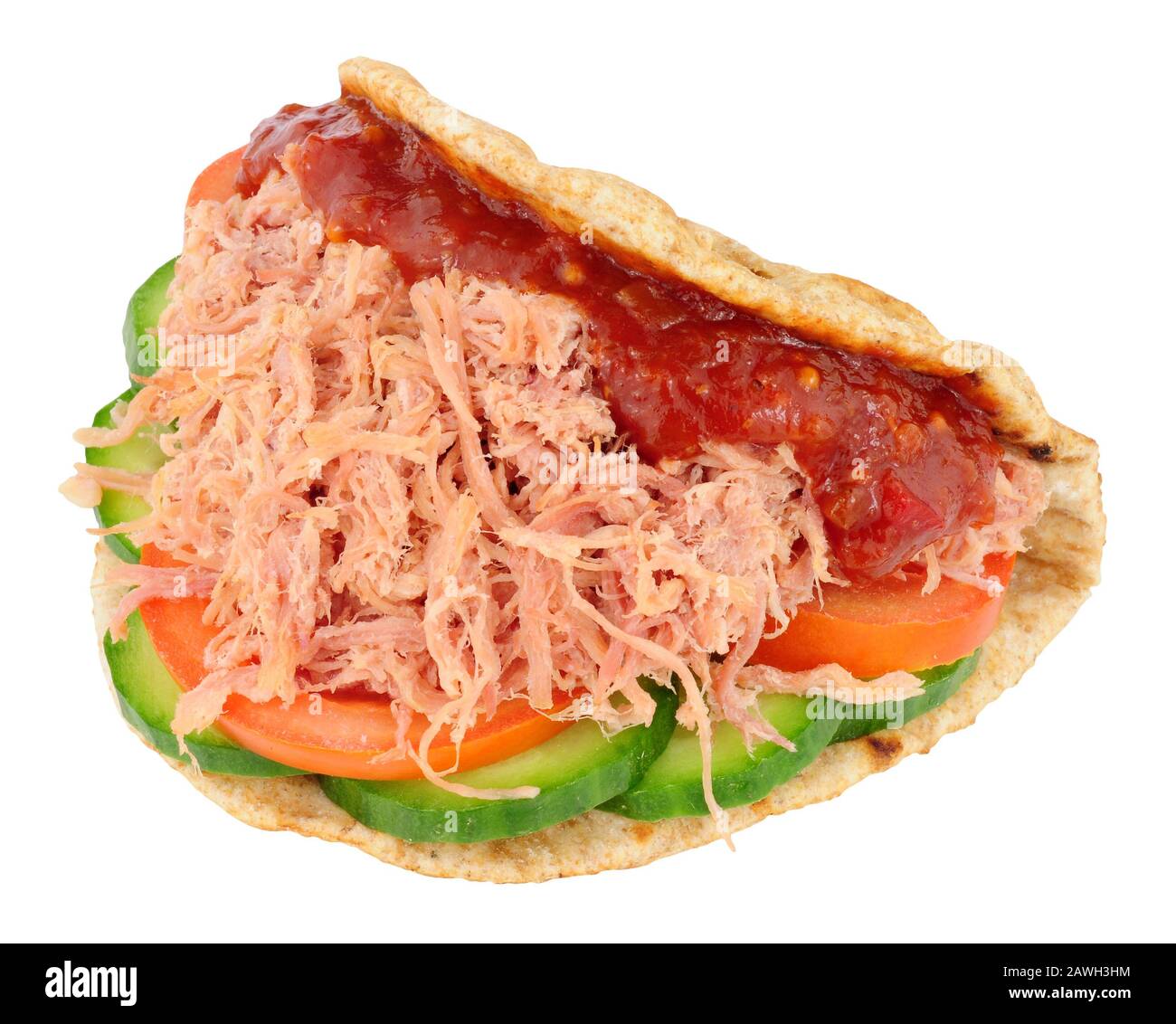 Shredded ham salad sandwich in a folded wholemeal flatbread isolated on