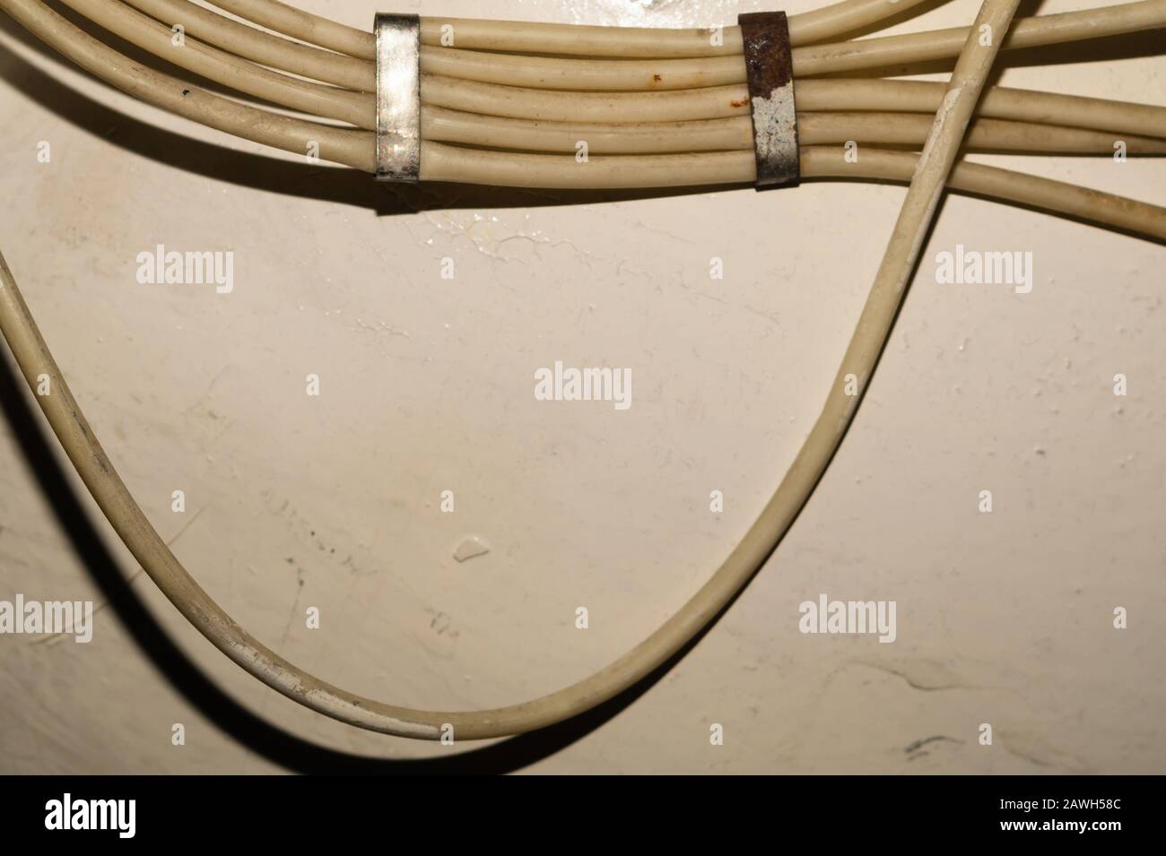 Old electrical wires or cables hanging on the wall. industrial background Stock Photo