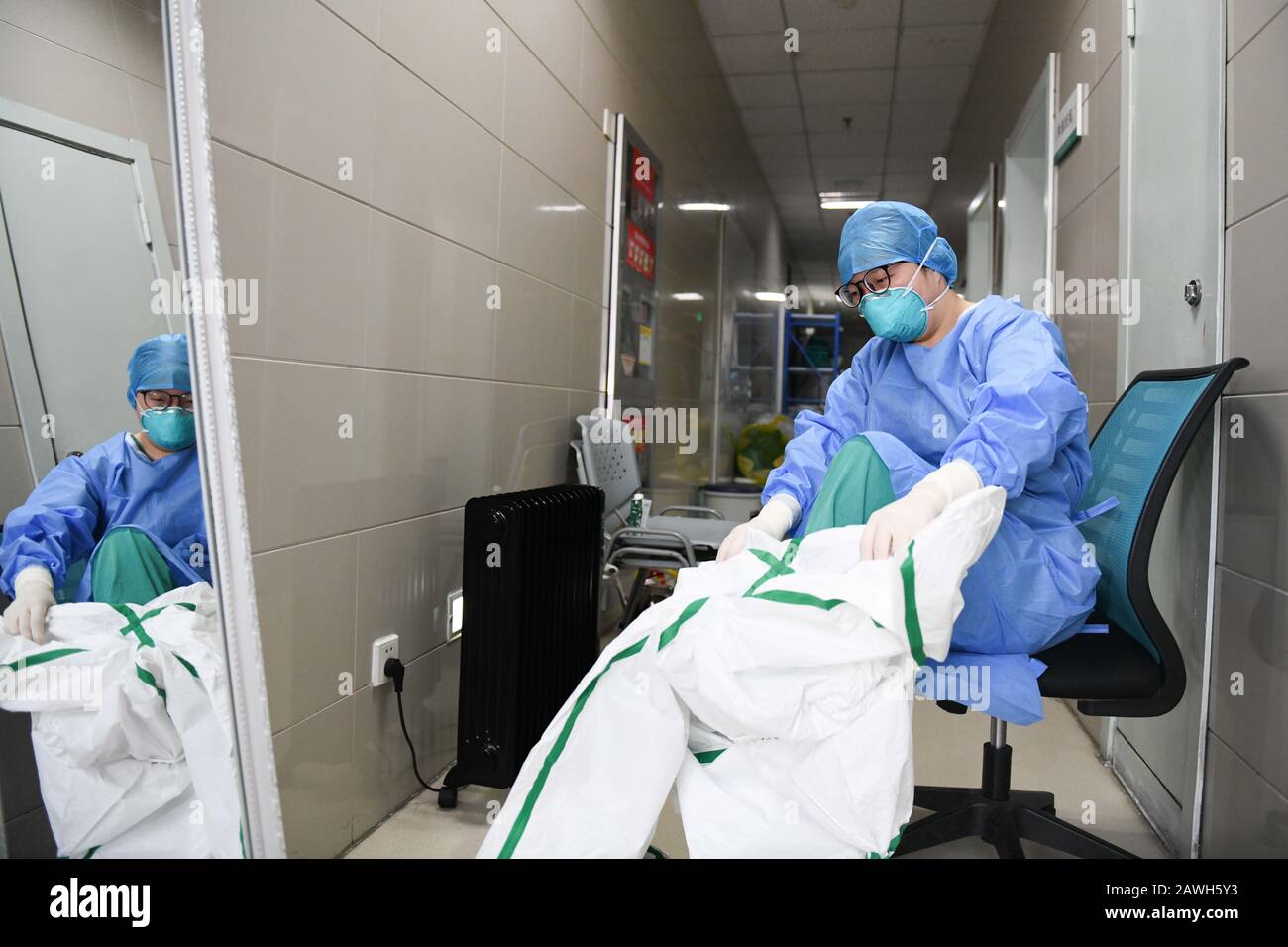 (200209) -- HEFEI, Feb. 9, 2020 (Xinhua) -- Fang Ji puts on a protective suit before entering the isolation ward in the Second People's Hospital of Hefei in Hefei, capital of east China's Anhui Province, Feb. 6, 2020. Fang Ji, 34, is a nurse who works in the ICU (intensive care unit) of the Second People's Hospital of Hefei. After the outbreak of the novel coronavirus (2019-nCov), Fang and her colleagues stay 24 hours a day in the hospital taking care of patients in shifts. The balcony of Fang's house lies in front of the hospital. In order to comfort two little sons who miss her badly at home Stock Photo