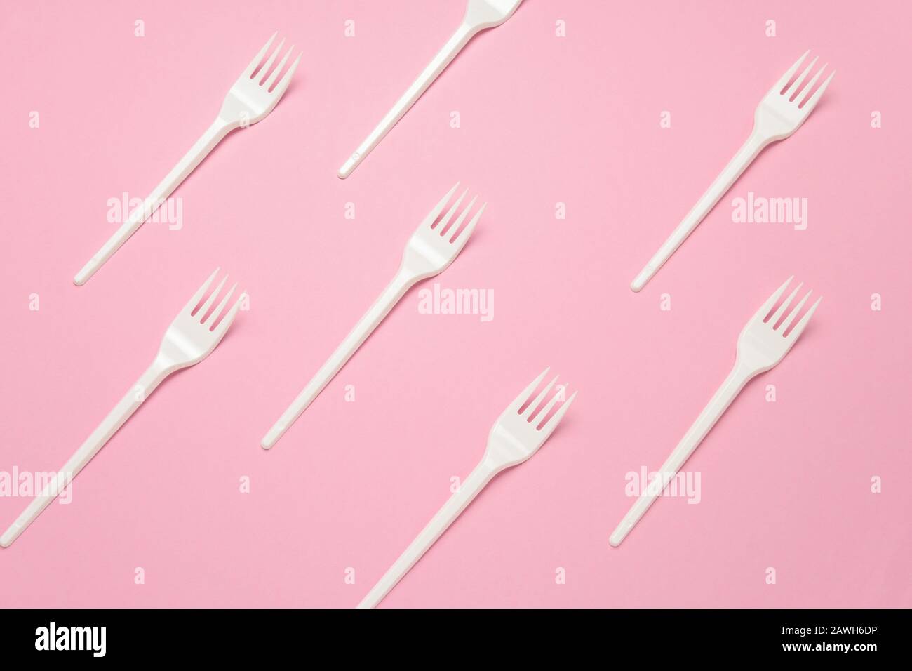 top view white plastic forks pattern on a pastel pink background Stock Photo