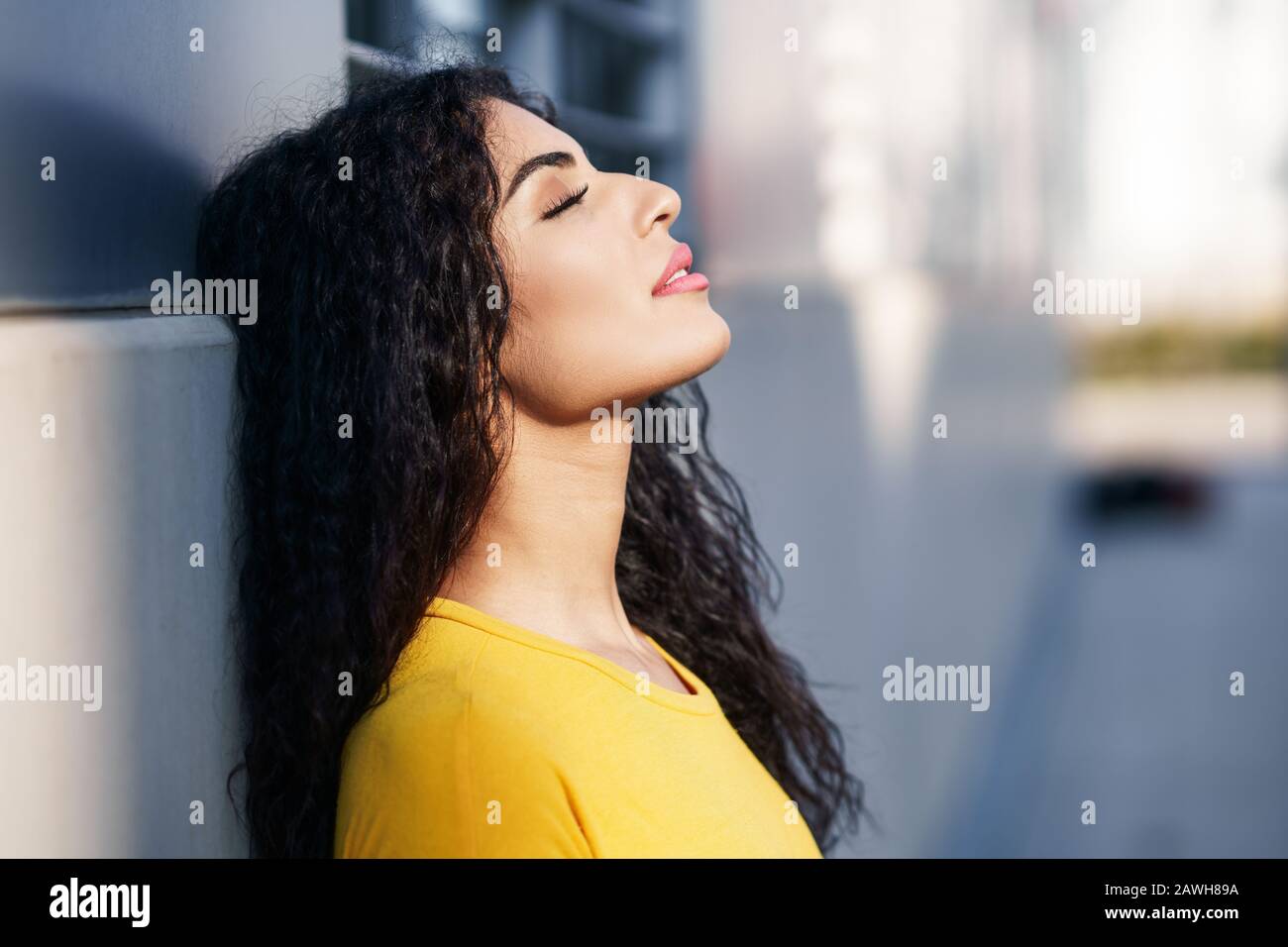 Arab woman with eyes closed in urban background Stock Photo