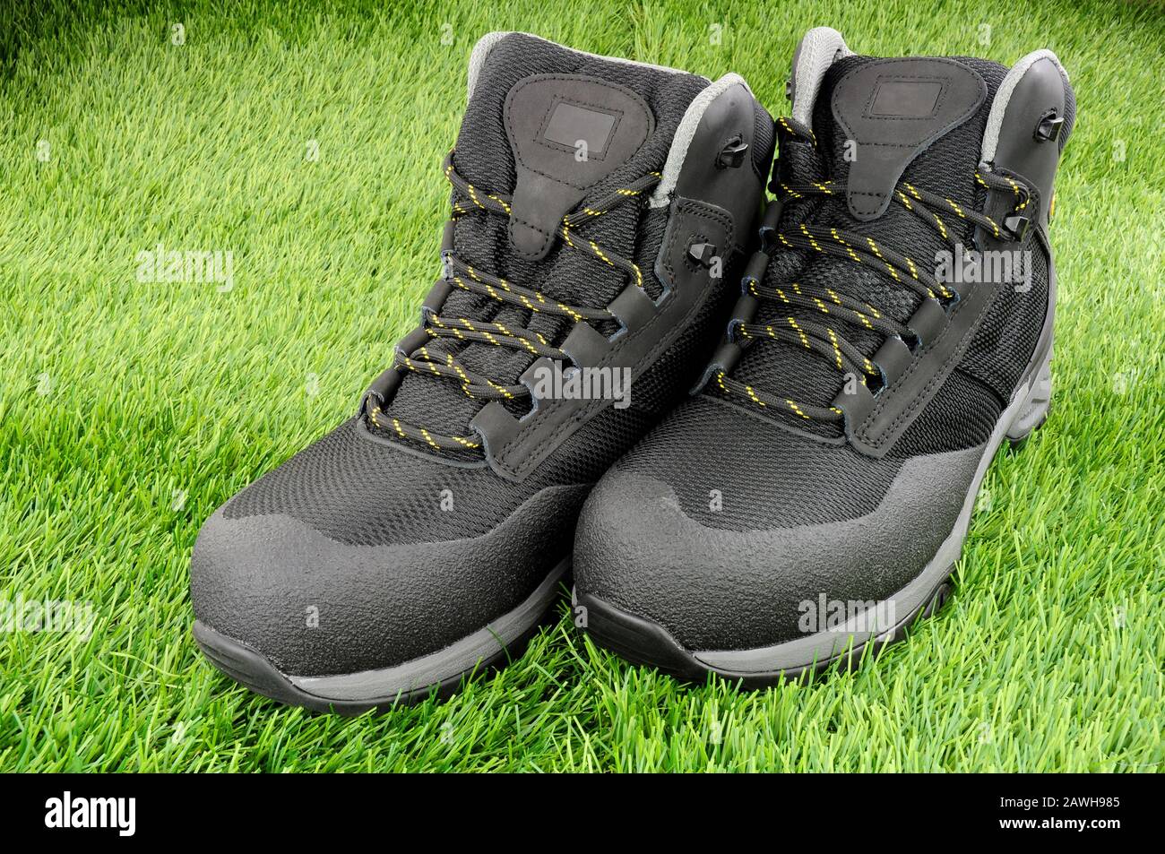 Pair of new work safety protection boots on an artificial grass
