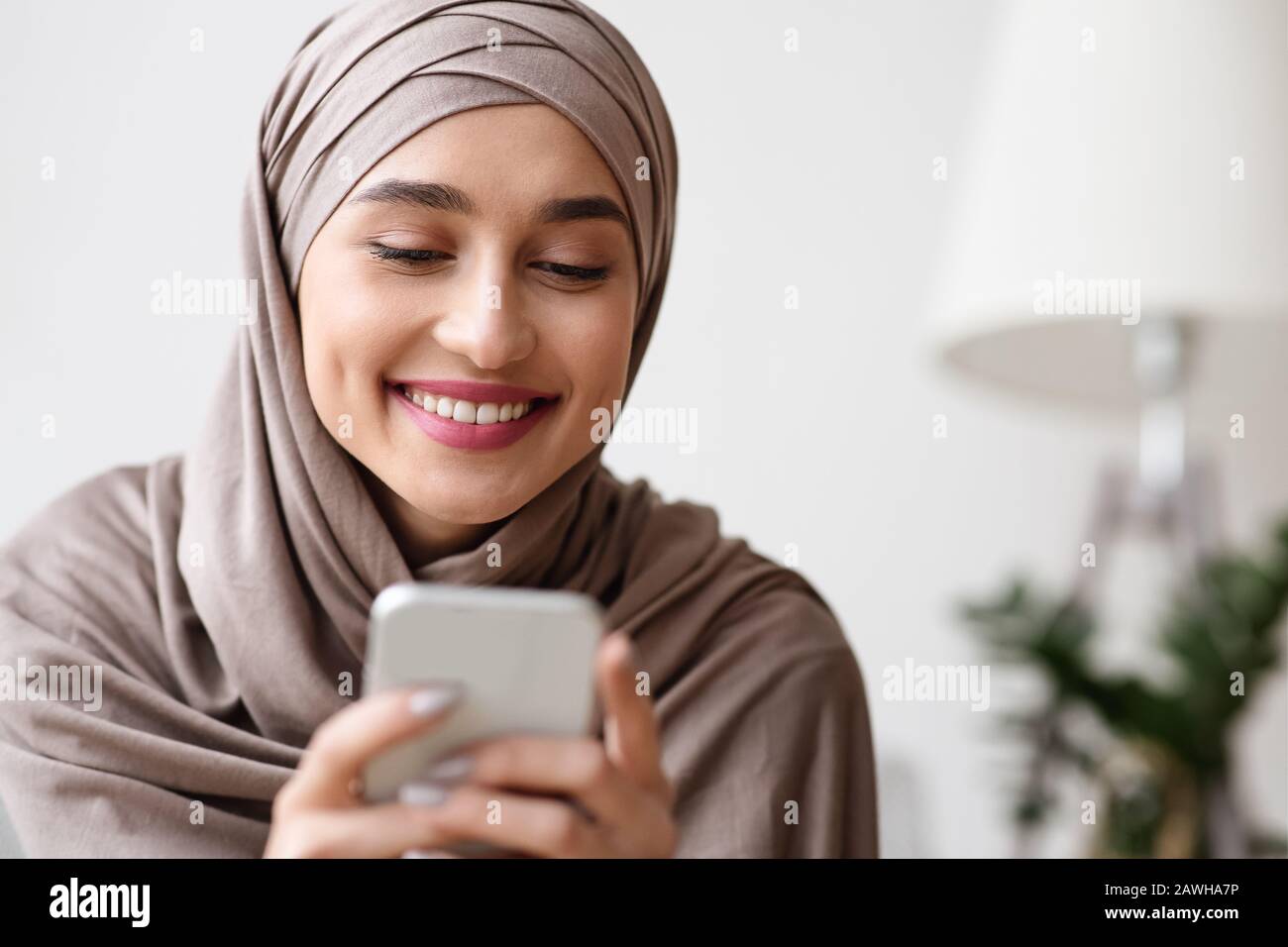 Happy Muslim Girl In Hijab Reading Message On Smartphone And ...