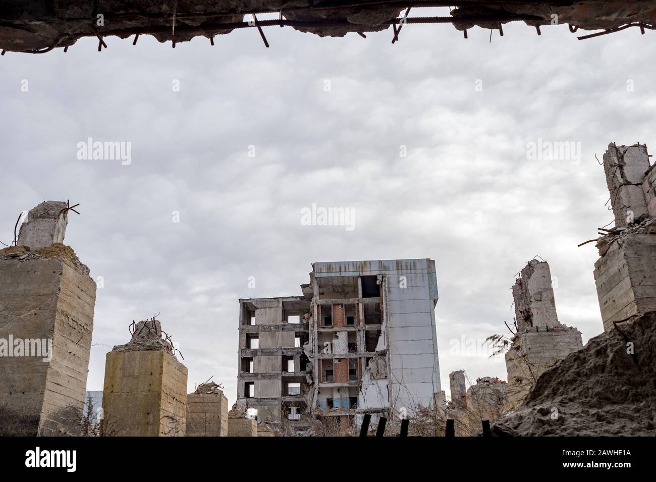 View through a gap in the concrete wall with protruding rebar on the  remains of concrete Foundation piles against the background of a destroyed  buildi Stock Photo - Alamy