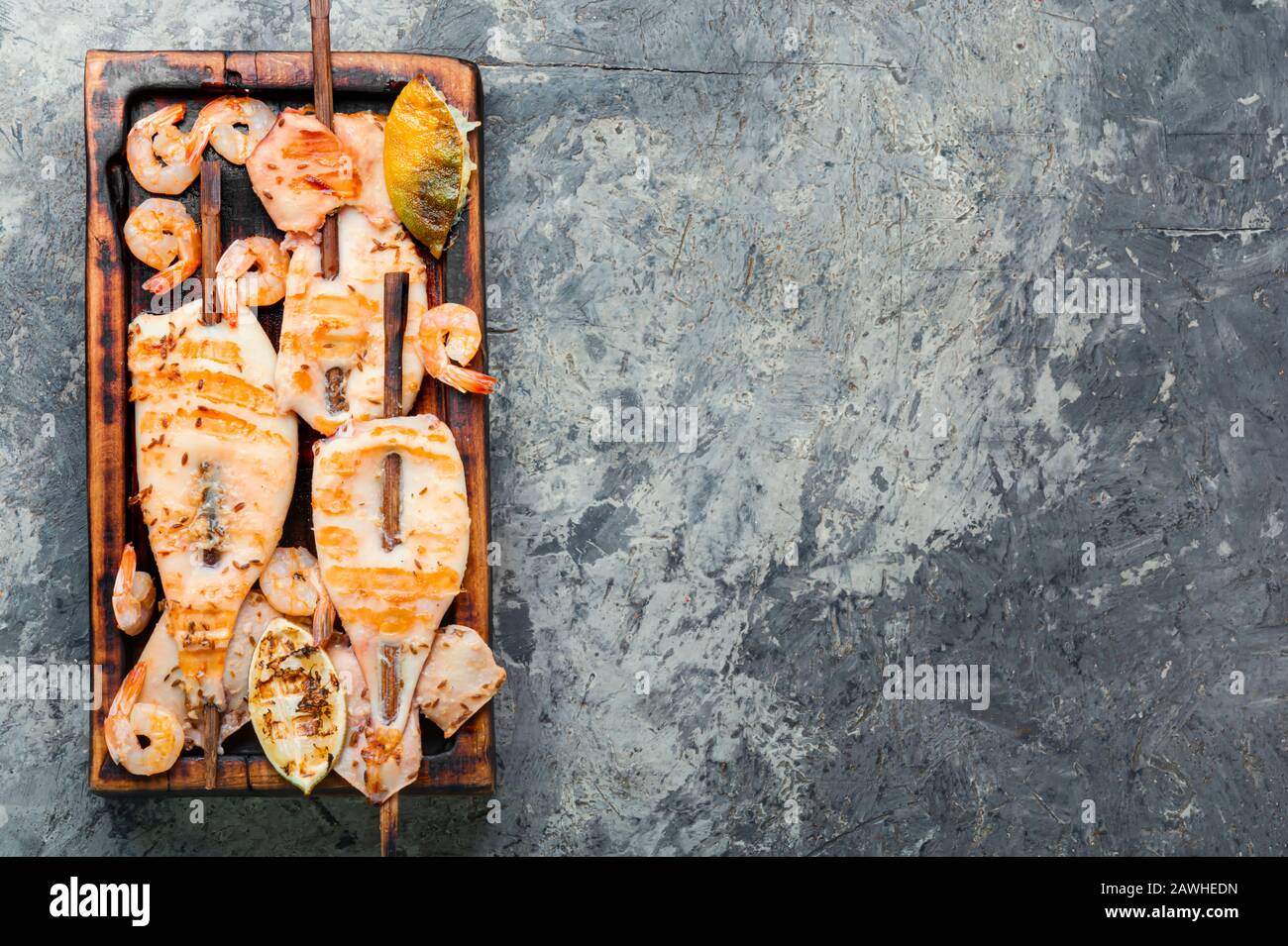 Grilled squid skewers on a kitchen board.Grilled calamari Stock Photo