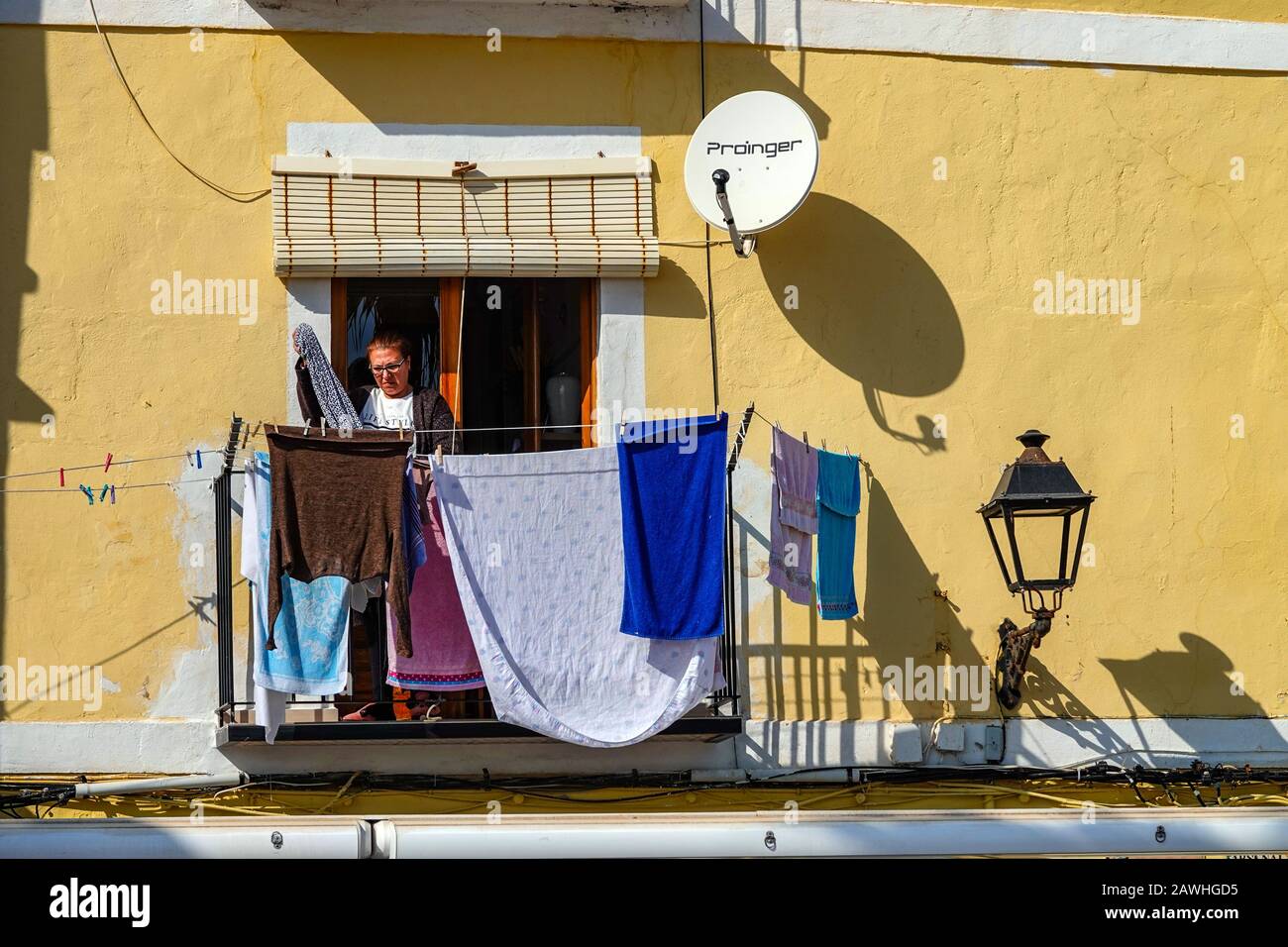 Solitary man on terrace with washing, The famous coloured colourful houses of Villajoyosa, Costa Blanca, Spain Stock Photo