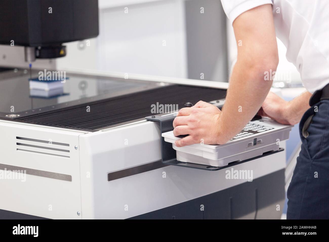 Technician is using joystick and keyboard to operate electronic device Stock Photo