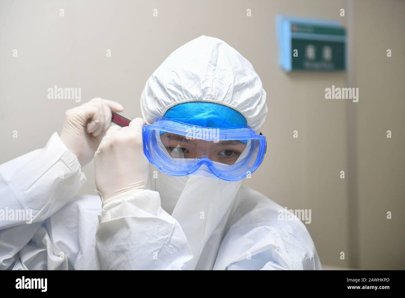 (200209) -- CHANGSHA, Feb. 9, 2020 (Xinhua) -- Yi Junfeng wears protective goggles at a fever clinic of Hunan People's Hospital in Changsha, central China's Hunan Province, Feb. 7, 2020. Amid the current novel coronavirus outbreak, 22-year-old male nurse Yi Junfeng has volunteered to join the battle against the epidemic. After a series of professional trainings, he now works as a front-line fever clinic nurse at Hunan People's Hospital in Changsha. Yi believes that a male nurse has comparative advantages in terms of physical strength and etc, and can play an important role in combating contagi Stock Photo