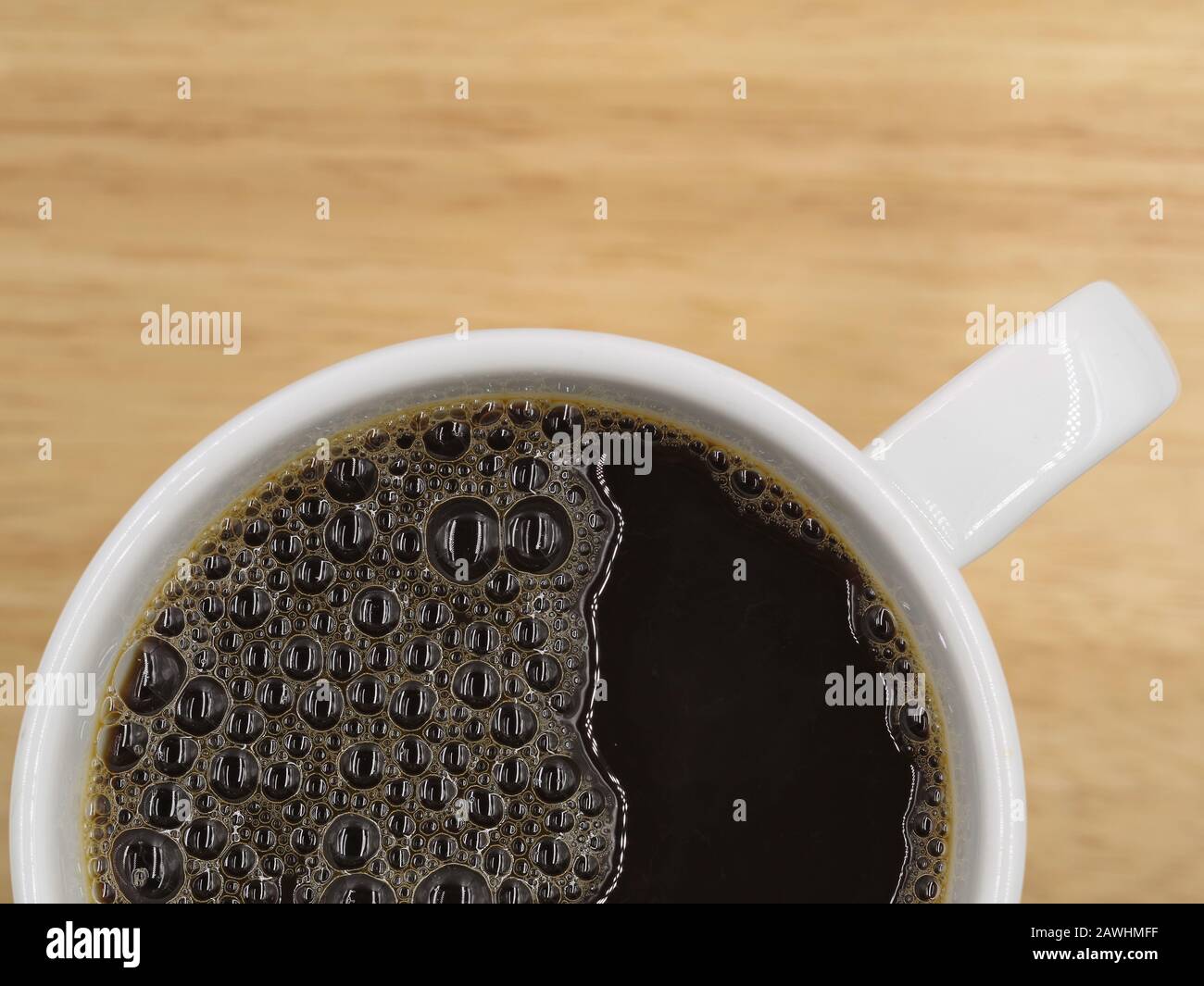 White cup of fresh hot black coffee on wooden table. Top view with copy space Stock Photo