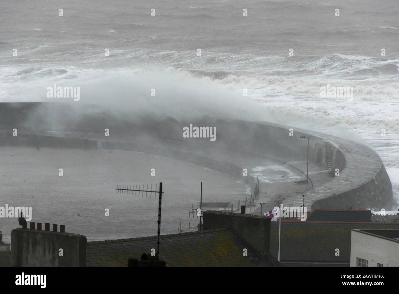 Lyme Regis, Dorset, UK.  9th February 2020. UK Weather.  Large stormy waves from Storm Ciara smash against the historic Cobb Harbour wall at Lyme Regis in Dorset.  Picture Credit: Graham Hunt/Alamy Live News Stock Photo