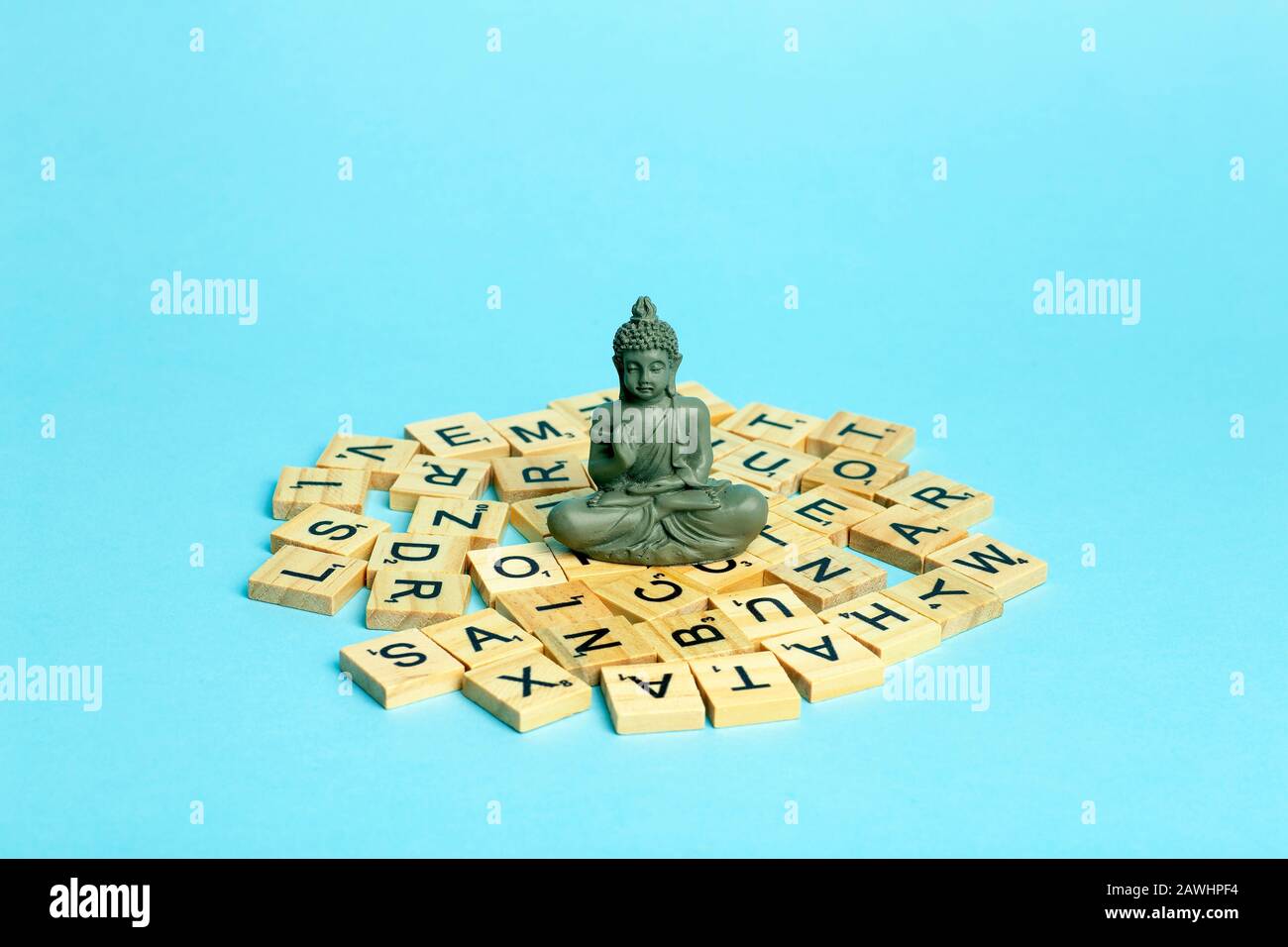 Mind concept. A meditating figure sits on a pile of different letters. The concept of thinking, mind, development and creativity. Stock Photo