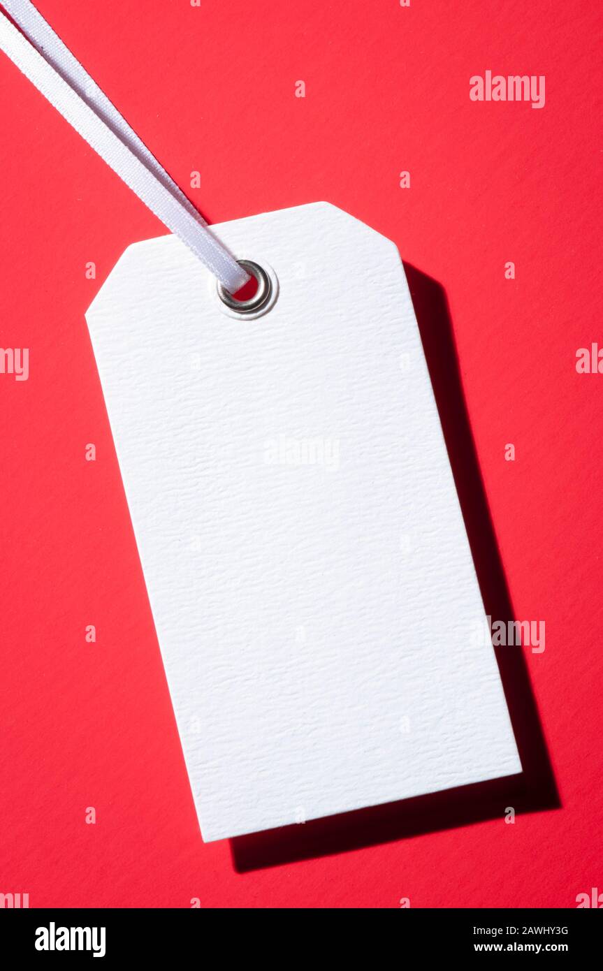 Blank white gift tag casting a shadow on red background Stock Photo Alamy