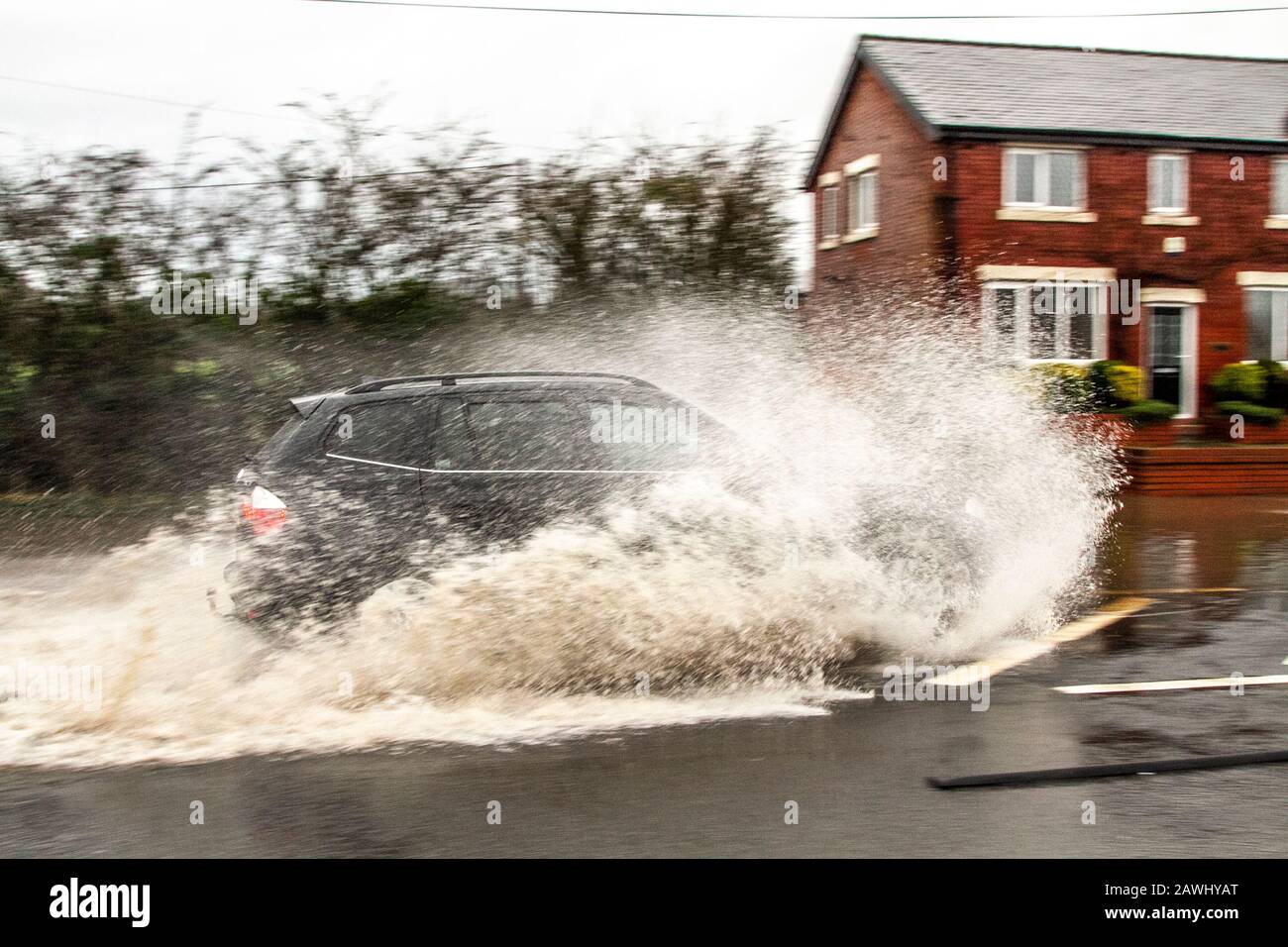 Motorists drive through flood water hires stock photography and images