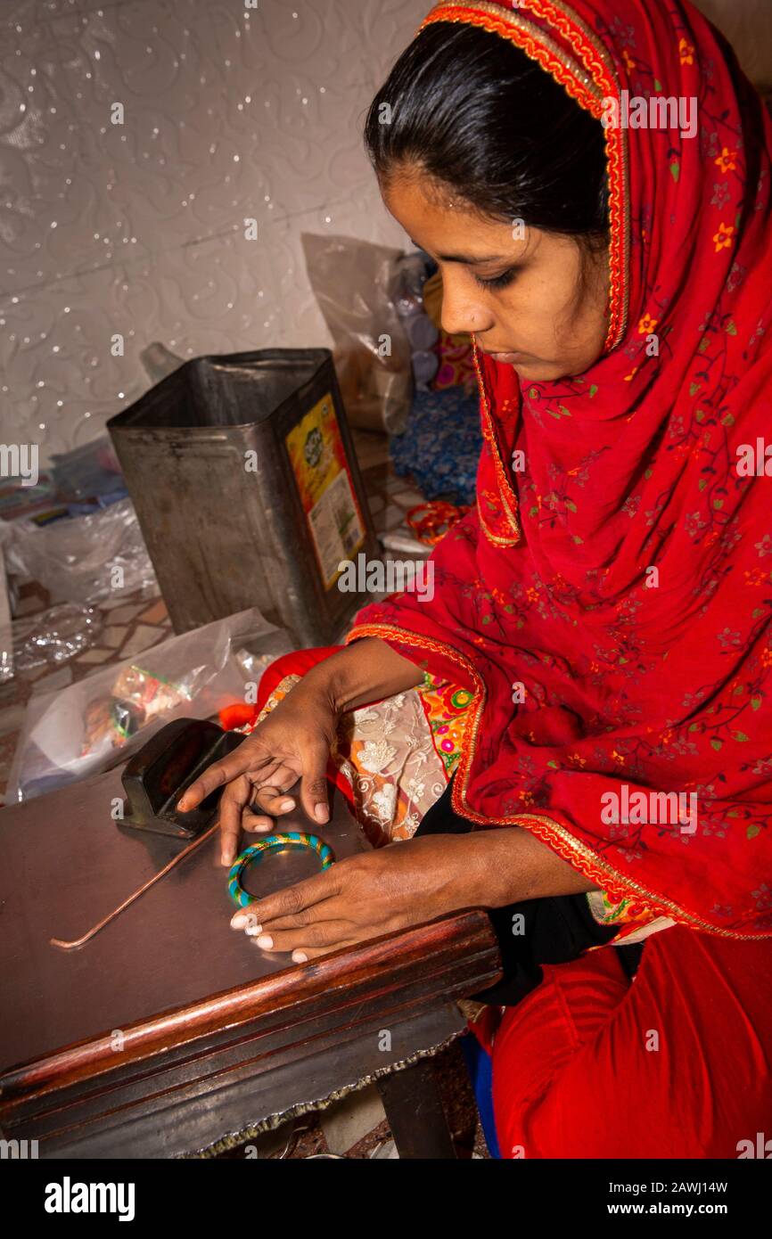 India, Rajasthan, Shekhawati, Nawalgarh, making traditional lac bangles by hand, young woman rolling hot bangle into shape Stock Photo
