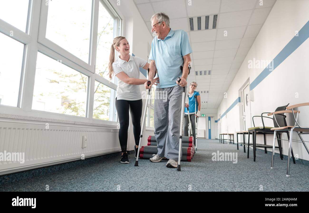 Seniors In Rehabilitation Learning How To Walk With Crutches Stock Seniors in rehabilitation learning how to walk with crutches stock