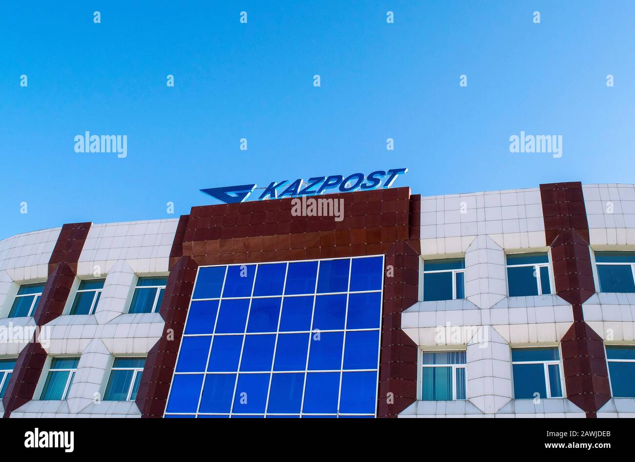 Kokshetau/ Kazakhstan - February 6, 2020: Kazpost branch with logo on it on blue sky background. Building of National postal service of Kazakhstan. Stock Photo