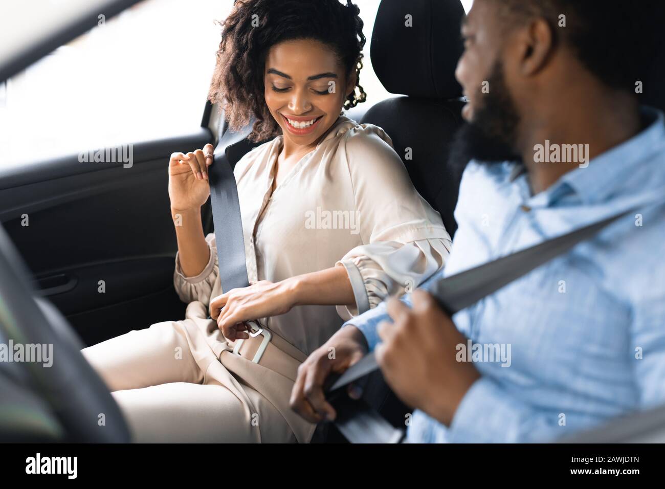 Couple In Car Putting On Seat Belts In Dealership Showroom Stock Photo