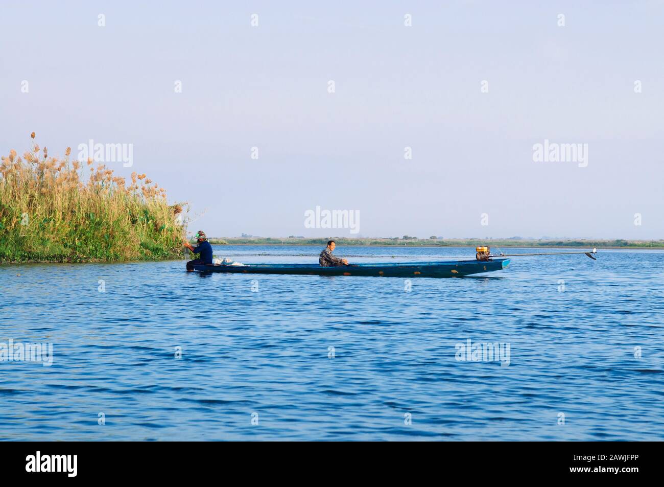 JAN 13, 2019 Udonthani, Thailand - Thai fisheman boat in peaceful Nong Harn lake, Udonthani - Thailand. Wooden boat under beautiful morning sky over l Stock Photo