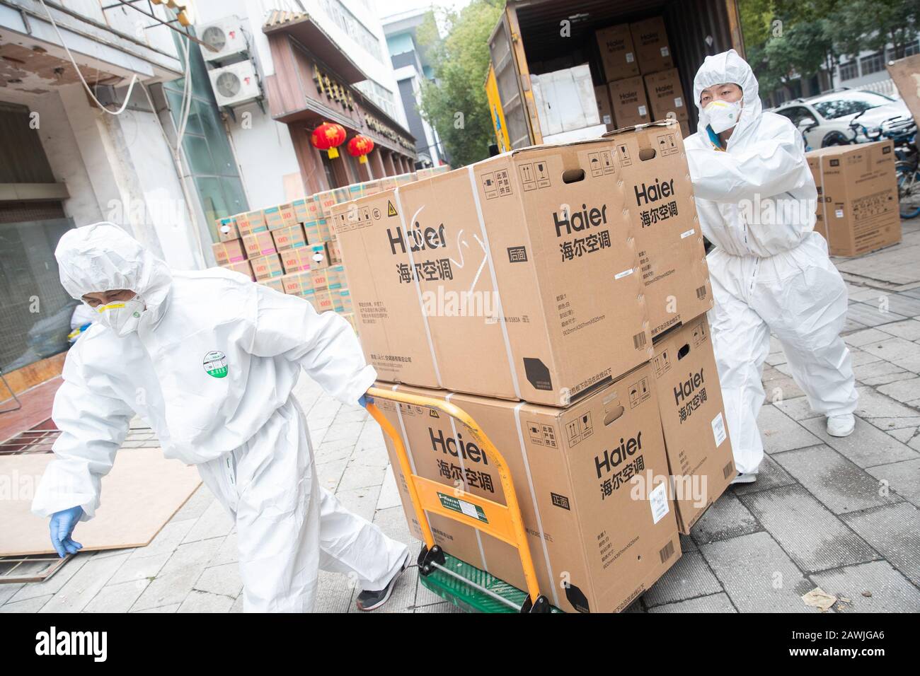 Workers of Chinese retailer Suning.com wearing protecitve clothing for prevention of the new coronavirus and pneumonia deliver electronical appliances Stock Photo