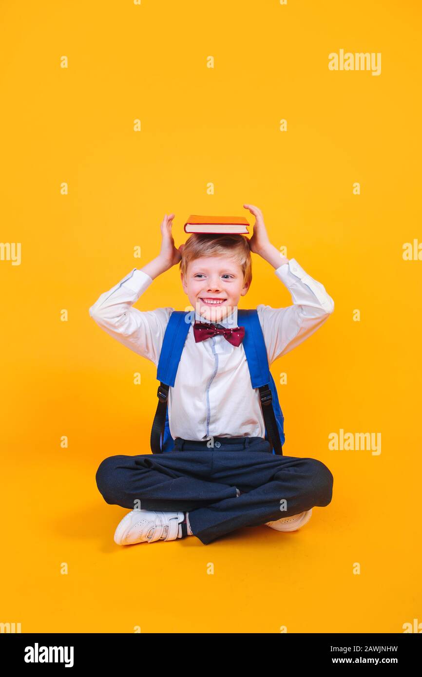 Young atractive boy wearing school unifor while holding his school books on heard Stock Photo