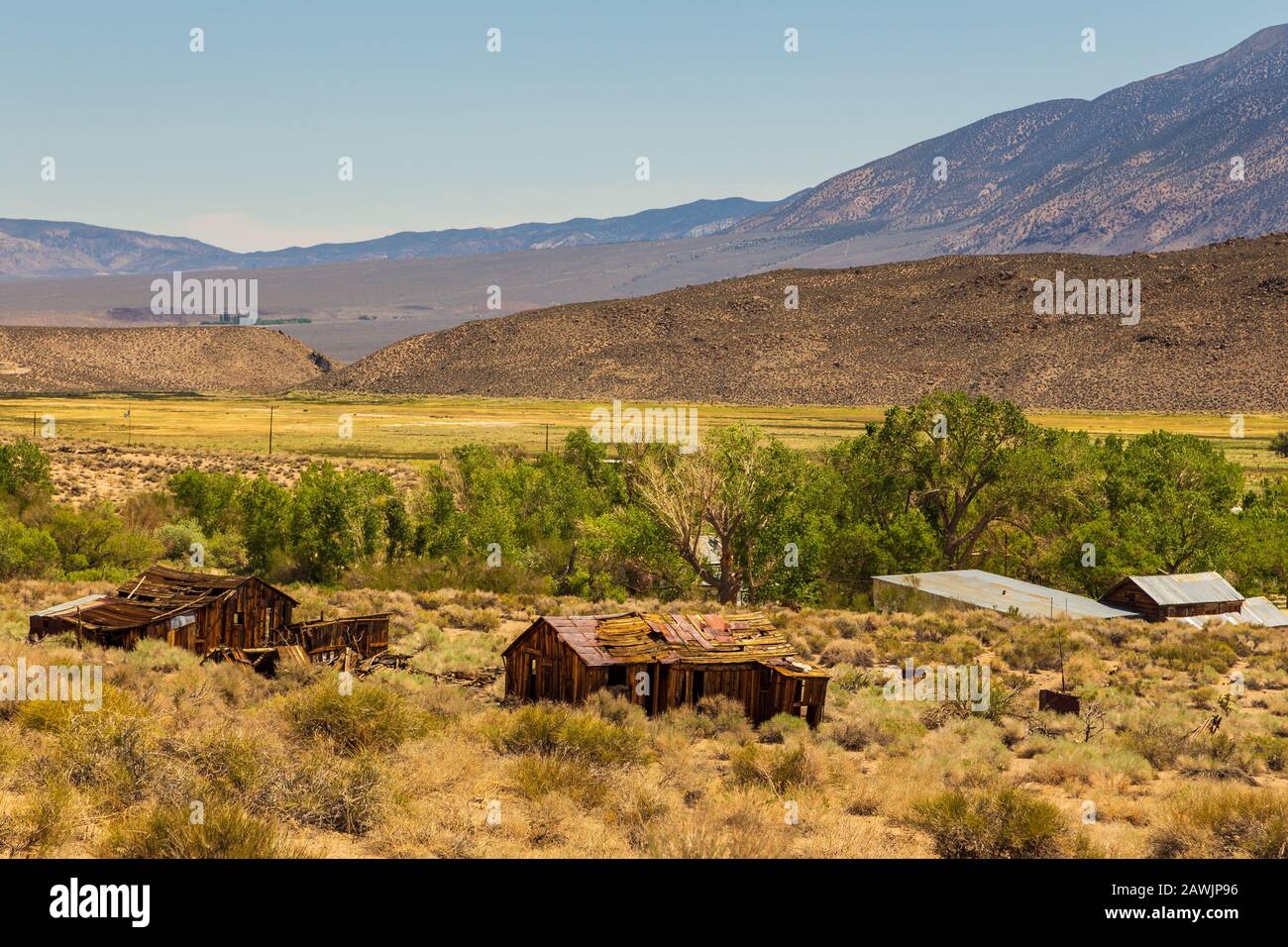 Old, wooden resort buildings next to hot springs. Snow-capped Sierra Nevada mountains in the background, Benton, California, USA. Stock Photo
