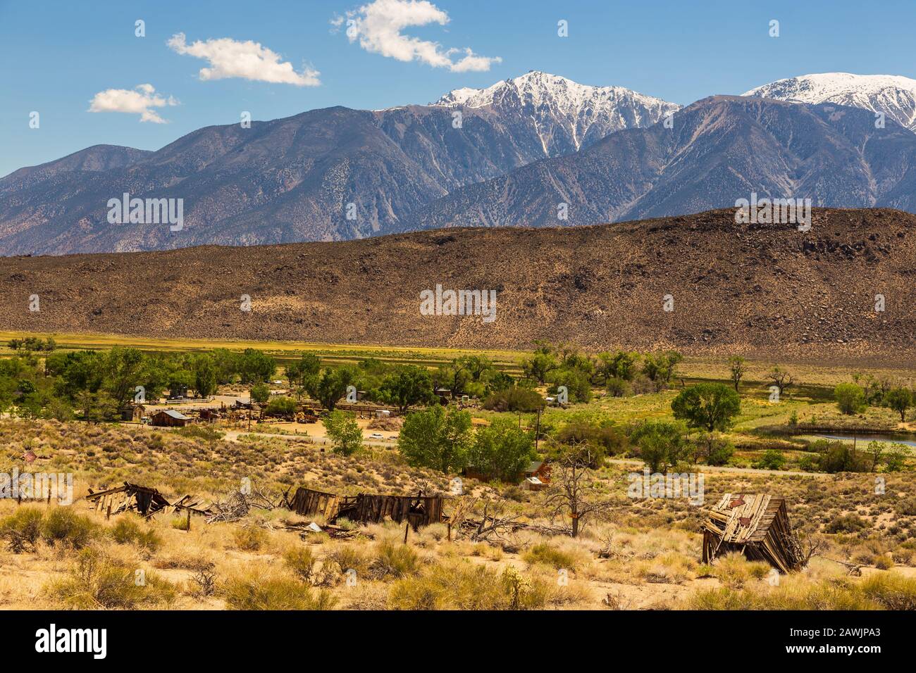 Old, wooden resort buildings next to hot springs. Snow-capped Sierra Nevada mountains in the background, Benton, California, USA. Stock Photo