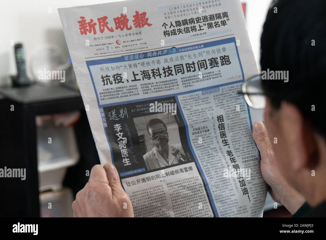 A local Chinese resident reads reports mourning Chinese doctor and coronavirus whistleblower Li Wenliang after he died from the new coronavirus and pn Stock Photo