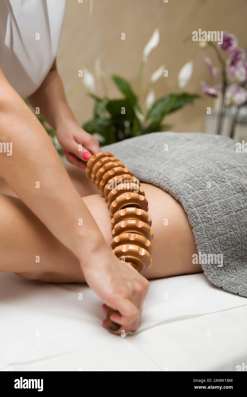 Closeup of the maderotherapy anti-cellulite massage with wooden roller  massager Stock Photo - Alamy