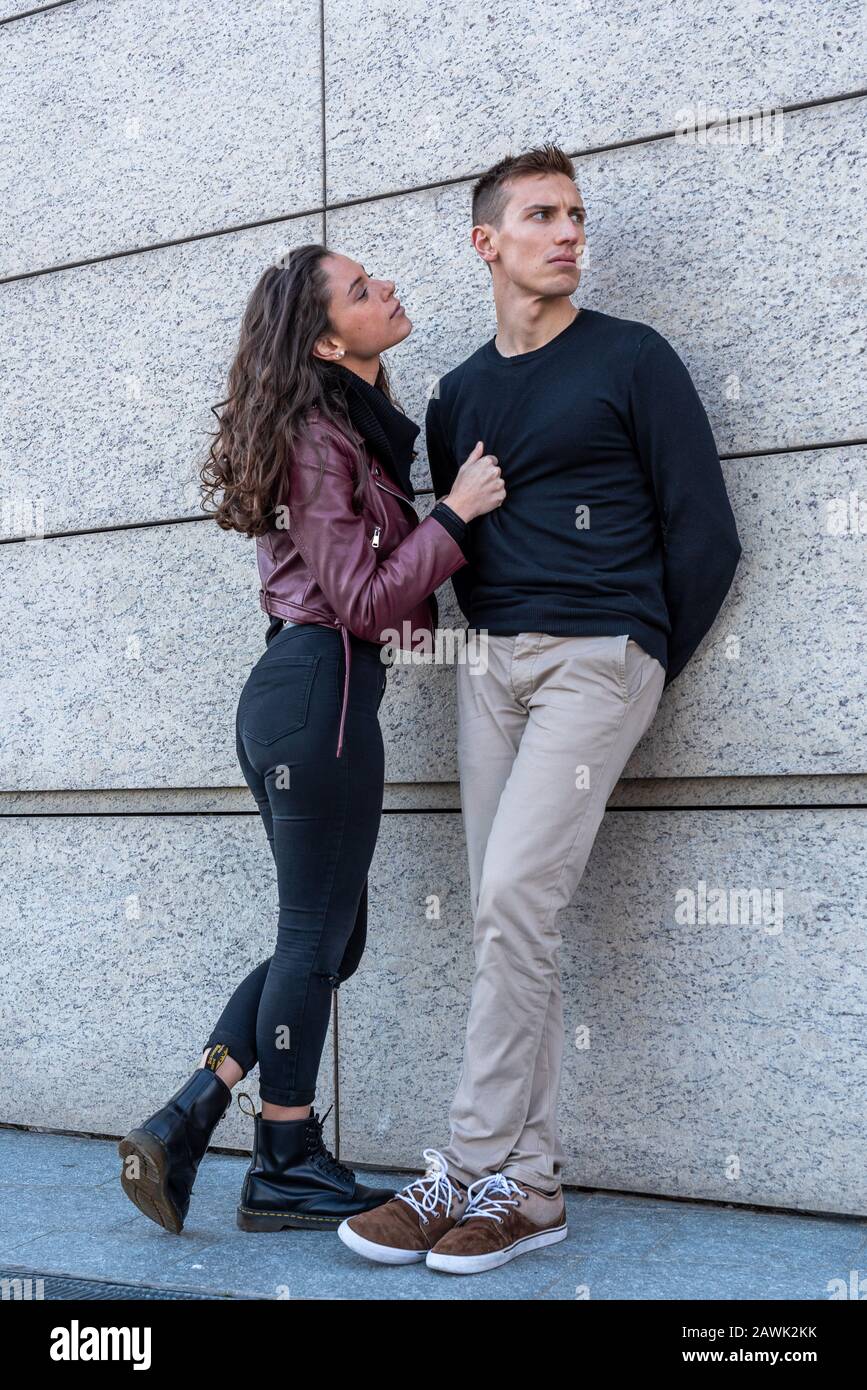 quarrel between lovers, she tries to get attention and apologizes to her boyfriend, he does not look at her and he's disrespectful, Love and feelings Stock Photo