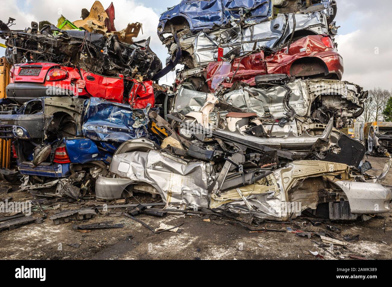 scrap cars stacked on top of each other at a dismantling industrial site Stock Photo
