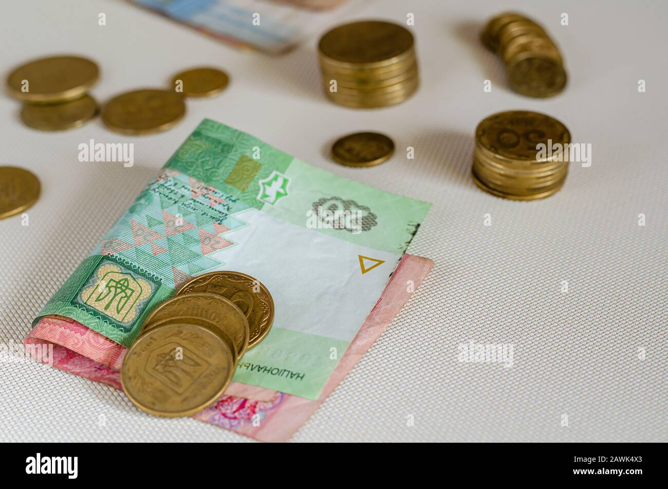 Piles of coins and paper bills. Different denomination. Close-up. Selective focus. Eye level shooting. Stock Photo