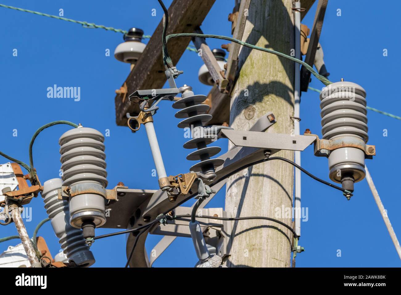 Overhead feeder power line on pole with fuse cutout switch for electrical utility distribution circuit overload and surge protection Stock Photo
