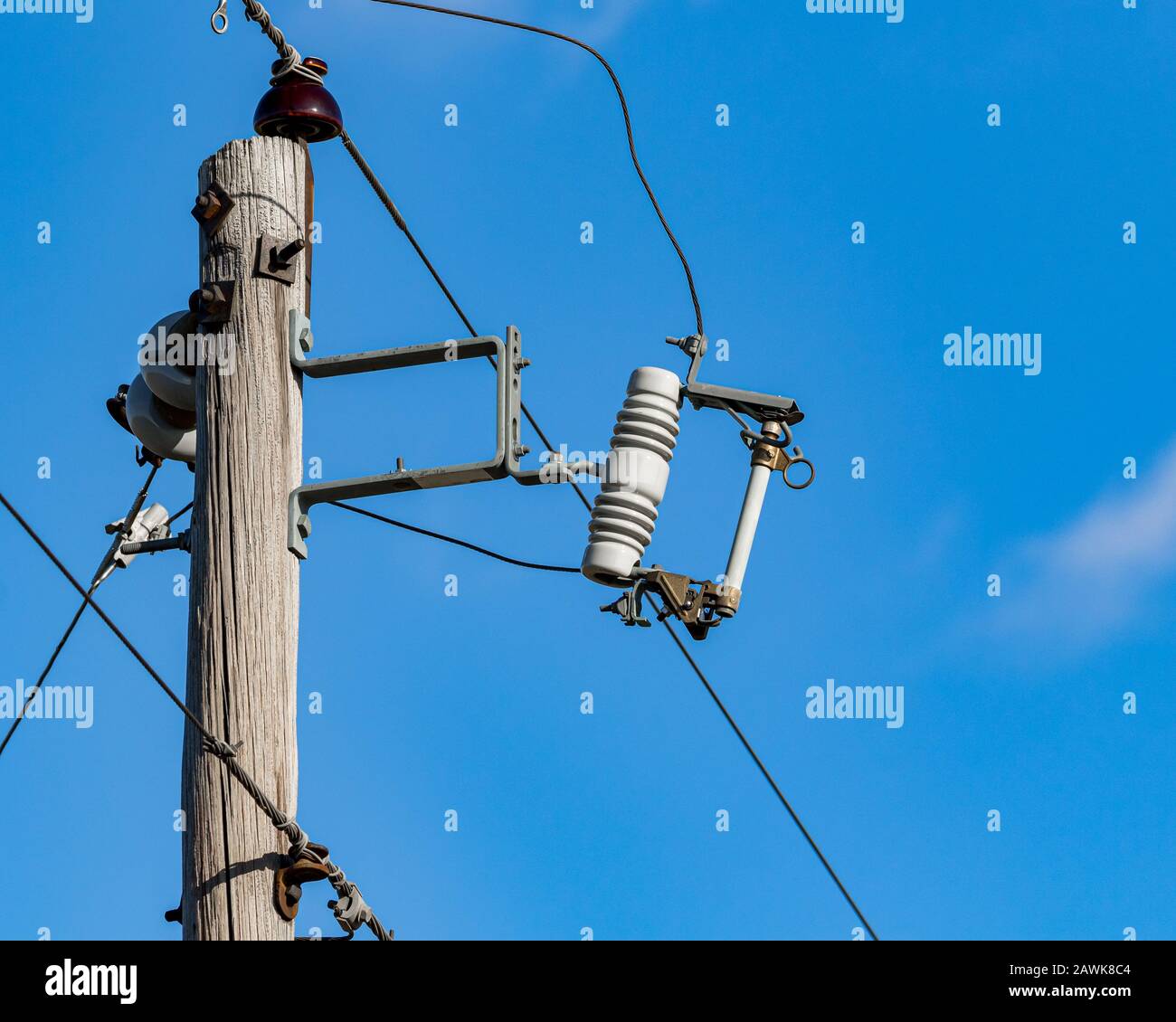 Overhead feeder power line on pole with fuse cutout switch for electrical utility distribution circuit overload and surge protection Stock Photo