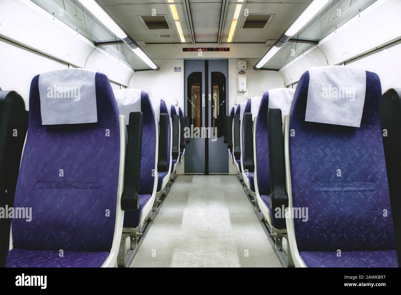 Interior of train carriage between rows of empty chairs Stock Photo