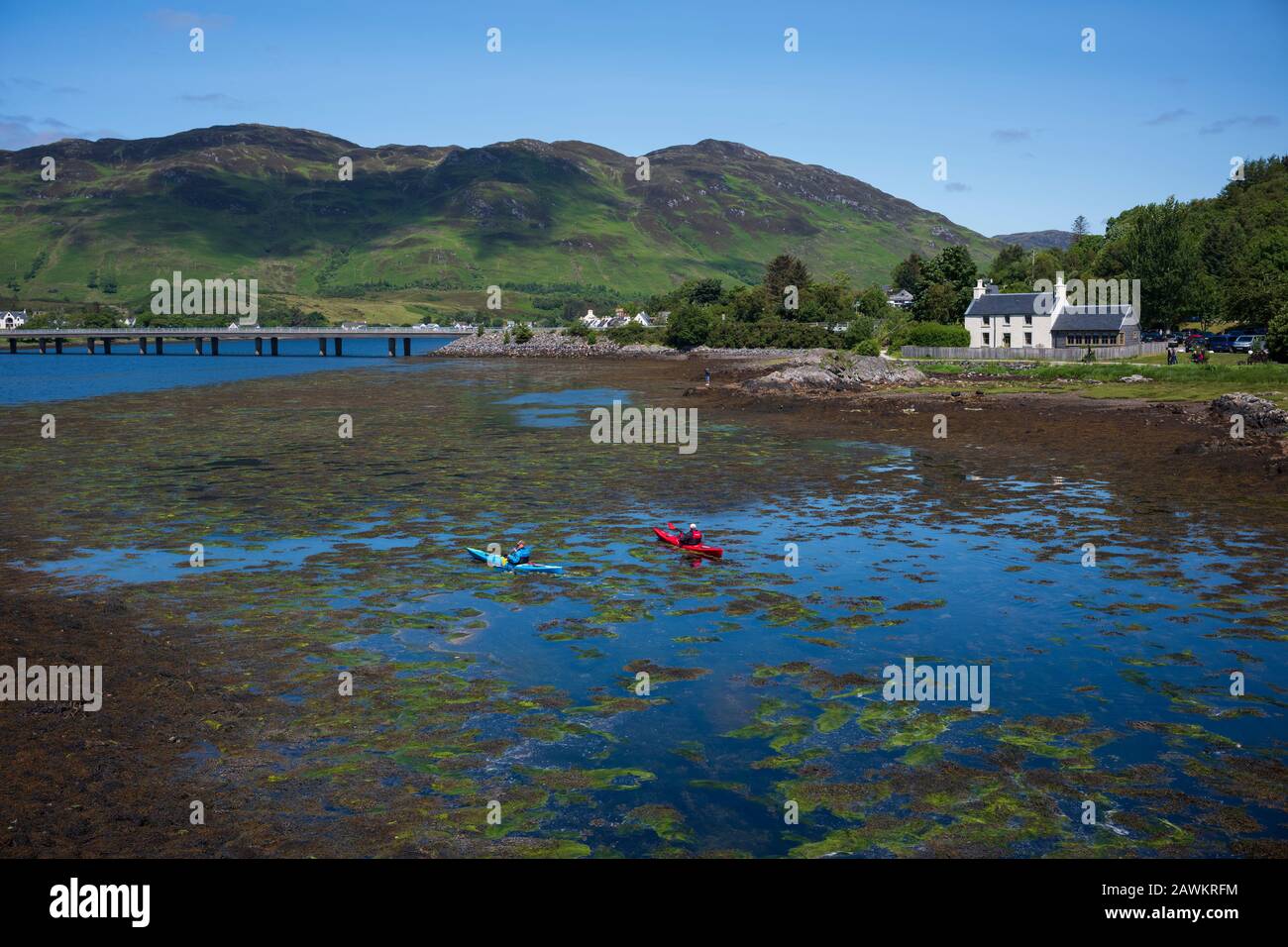 Dornie, Scotland/UK-June 26, 2019: Two kayakers paddle through the waters of Loch Duich near Eilean Donan Castle, a 13th Century Castle in the Highlan Stock Photo