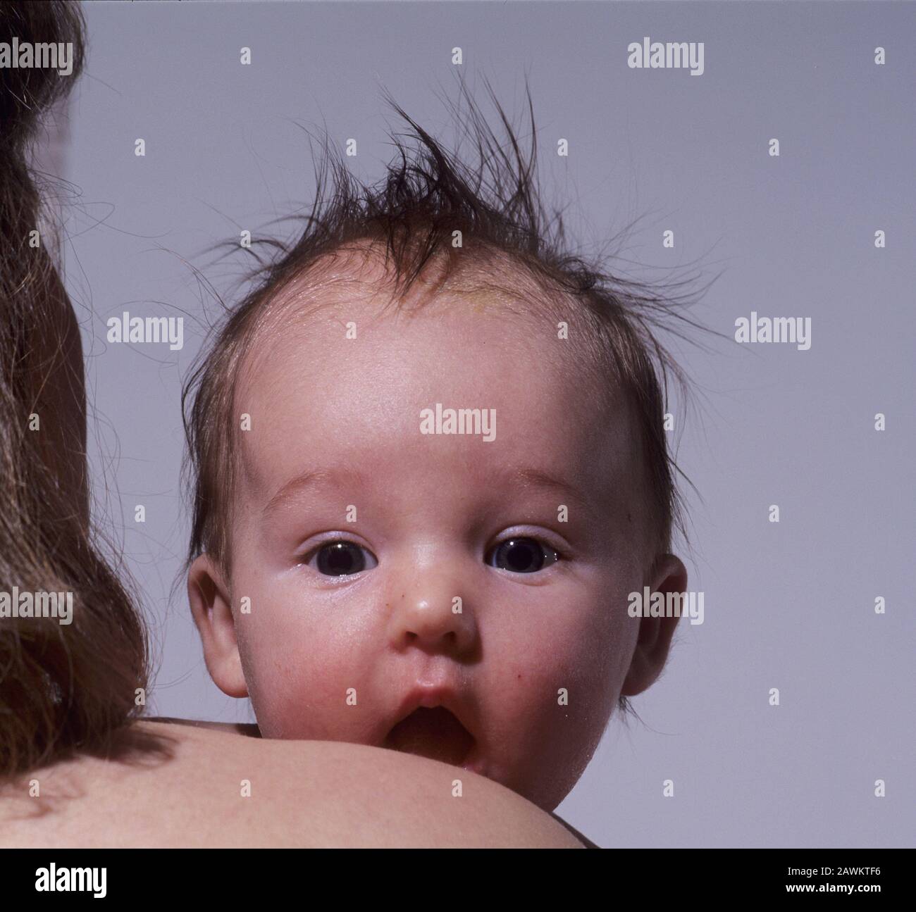 Surprised baby looking over shoulder Stock Photo Alamy