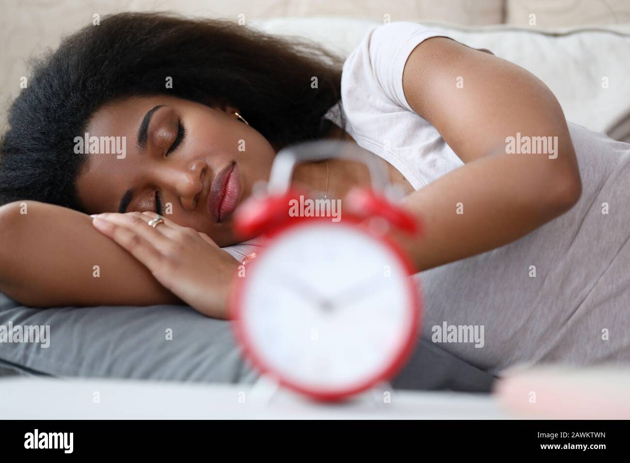 Woman is sleeping soundly, setting an alarm while Stock Photo Alamy