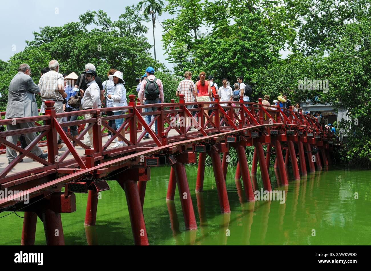 Hanoi, Vietnam, August 3 2010: Vietnamese people walking on  The Huc red bridge leading to Jade island. Hanoi, Vietnam Stock Photo