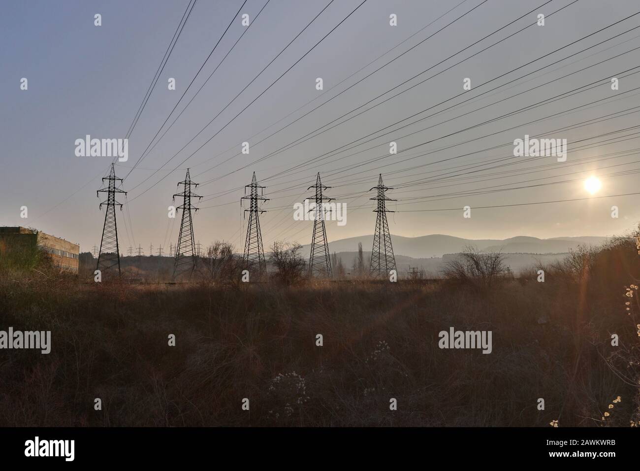 High voltage electric pole and transmission lines in the evening ...