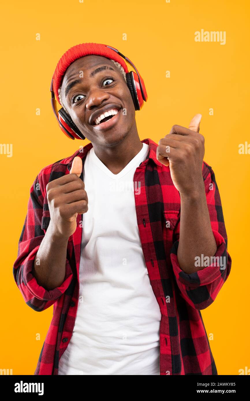 Funny American Black Man With Grimace On His Face Listens To Music On Yellow Background Stock Photo Alamy