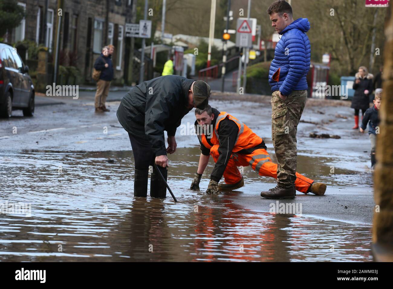 Marsden, UK. 9th February, 2020. Storm Ciara leaves a trail of damage in the Calder valley.  Rain has washed stones and  a railway sleeper onto the Rochdale to Todmorden Road.  A tree has fallen across the railway line.  A tractor is been used to take away flood water and empty it into the Rochdale canal.  Walsden, Calder Valley, West Yorkshire, UK. Credit: Barbara Cook/Alamy Live News Stock Photo