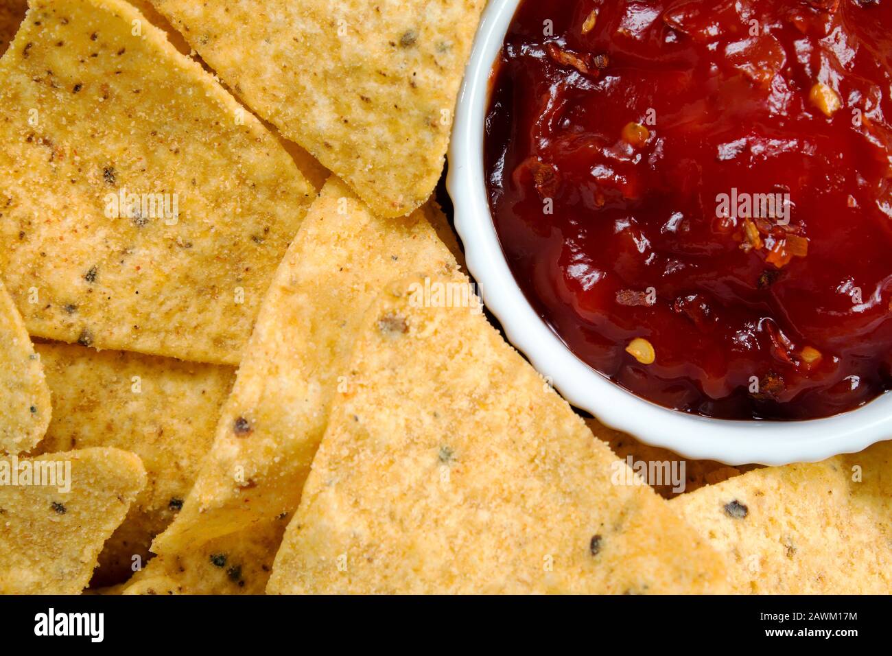 Nachos with a chilli sauce dip from a close up overhead perspective